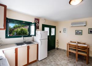 a kitchen with a white refrigerator and a sink at Lefkada Sunset House in Kalamitsi