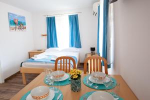 a room with a table and two chairs and a bed at Arcobaleno Apartments in Piran