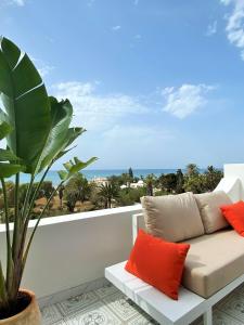un sofá en un balcón con vistas al océano en Roof Top Pied dans l'Eau Panoramic View, 80 meters from Seaside en Hammamet
