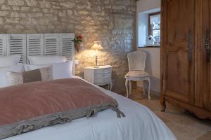 a bedroom with a bed and a table with a lamp at la clef des champs in Lémeré