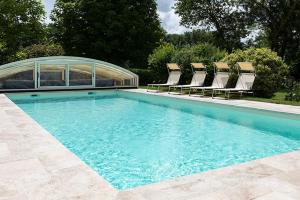 a swimming pool with chairs and a group at la clef des champs in Lémeré