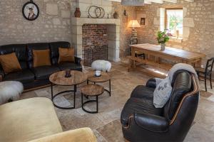 a living room with a couch and a fireplace at la clef des champs in Lémeré