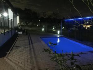 a swimming pool in a yard at night at SimbaSun Cottages in Midrand