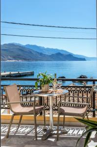 una mesa y sillas en un balcón con vistas al océano en Harbour Studios And Apartments, en Palaiochóra