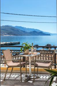 a table and chairs on a balcony with a view of the ocean at Harbour Studios And Apartments in Palaiochora