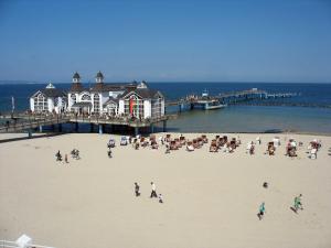 eine Gruppe von Menschen am Strand in der Nähe eines Piers in der Unterkunft Selliner Ferienappartements in Ostseebad Sellin