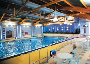 a large swimming pool with people in the water at 127cs HOBURNE NAISH HOLIDAY PARK in Highcliffe