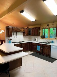 cocina con armarios de madera y encimera blanca en Spacious Resort Style Retreat Sleeps 20 en Fairbanks