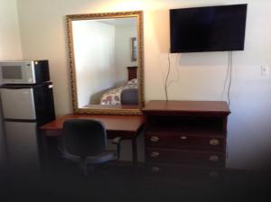 Habitación con escritorio con espejo y nevera. en Summit Inn - Dayton en Dayton