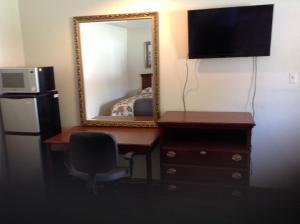 a room with a desk with a mirror and a refrigerator at Summit Inn - Dayton in Dayton