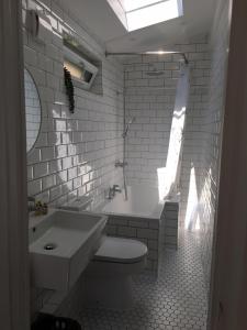 a bathroom with a toilet and a tub and a sink at Shoemakers Cottage in Ramsgate