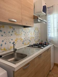 una cucina con lavandino e piano cottura di Cartari Apartment a Palermo