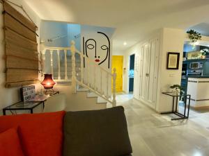 una sala de estar con una escalera con una cara pintada en la pared en Duplex céntrico frente a Hotel Monasterio, playas y pinares en las proximidades, en El Puerto de Santa María