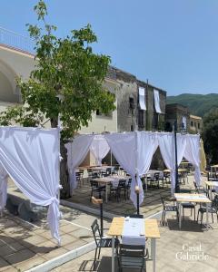 a group of tables and chairs with white curtains at Casal Gabriele in Lettere