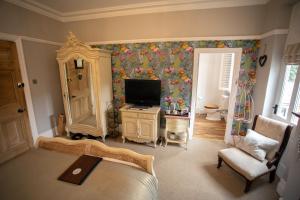 a living room with a television and a room with a bed at Treherne House & The Malvern Retreat in Great Malvern