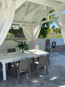 a white table and chairs under a white canopy at Porto Marina in Chrysi Ammoudia