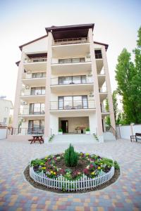 a large building with a flower bed in front of it at Villa San-Marina in Zatoka