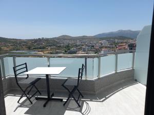 a table and chairs on a balcony with a view at Vila Olserd Shehu in Ksamil