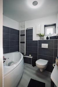 a bathroom with a white tub and a toilet at Tinytimeout Westerwald in Ellar