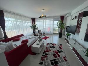 a bedroom with a bed and a couch and a tv at DreamView Mamaia SummerApt in Mamaia