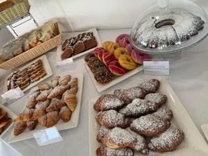 a table with different types of donuts and other pastries at Ganimede Hotel in Sperlonga