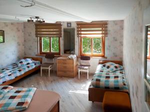 um quarto com 2 camas, uma secretária e 2 janelas em Jaunklāvi em Sīkrags