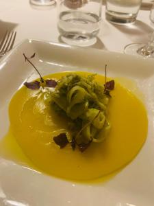 a plate of food with a yellow sauce on a table at Ganimede Hotel in Sperlonga