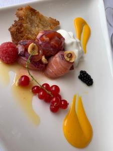 a plate of food with eggs bacon meat and fruit at Ganimede Hotel in Sperlonga