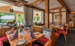 ein Restaurant mit Holztischen und -stühlen und einem Pferd im Hintergrund in der Unterkunft Landgasthaus Kurz Hotel & Restaurant am Feldberg - Schwarzwald in Todtnau