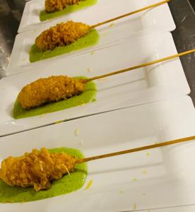 a row of white plates with food on chop sticks at Ganimede Hotel in Sperlonga