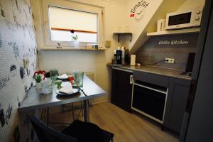 una pequeña cocina con mesa y microondas en Tinytimeout Westerwald, en Ellar