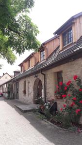 ein Steingebäude mit roten Blumen davor in der Unterkunft Kelterhotel Fröscher in Forchtenberg