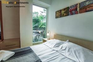 sypialnia z łóżkiem, oknem i stołem w obiekcie Baltic Apartments - Rezydencja Bursztyn w Świnoujściu
