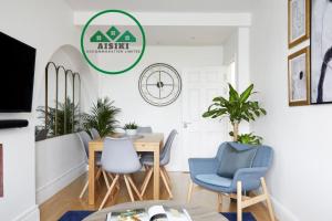 a dining room with a table and chairs at FW Haute Apartments at North Finchley, a 3 Bedroom and 2 Bathroom Pet Friendly Flat, King or Twin beds with FREE WIFI in Finchley