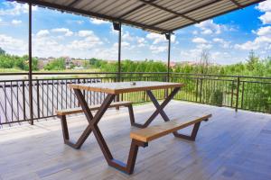 a wooden picnic table and bench on a deck at Apartmani Petra Sabac in Šabac