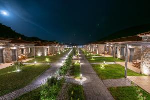 a long row of houses with lights at night at Αngelikon Luxurious Apartments in Agios Ioannis Kaspaka