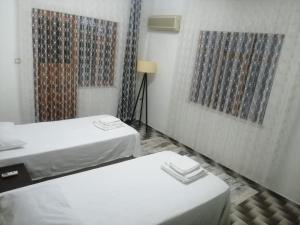 Zimmer mit 2 Betten und 2 Gemälden an der Wand in der Unterkunft Daltur Cıty Apart in Dalaman