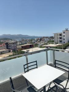 a white table and chairs on a balcony with a view at Vila Olserd Shehu in Ksamil