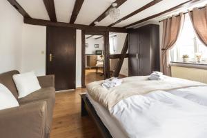 ein Schlafzimmer mit einem großen Bett und einem Sofa in der Unterkunft Zur Alten Weinkelter - bezauberndes Fachwerkhaus aus der Spätgotik von 1451 - Top Lage für Aktivitäten - Fahrradkeller in Ellenz-Poltersdorf