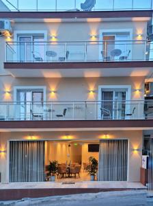 a building with a balcony with tables and chairs at Star Bay Luxury in Limenaria