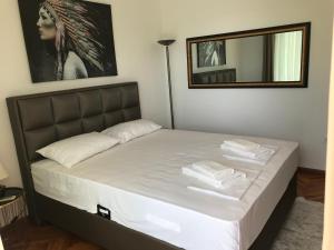 een slaapkamer met een bed met witte lakens en een spiegel bij Apartments Blue Heaven in Ulcinj