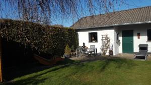 una casa blanca con una puerta verde y un patio en Ferienwohnung „Kersten“, en Bereborn