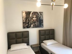 a room with two beds and a painting on the wall at Apartments Blue Heaven in Ulcinj