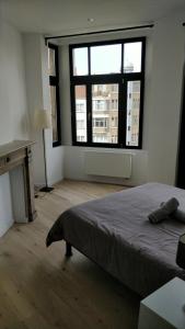 1 dormitorio con cama y ventana grande en Brussels flat en Bruselas