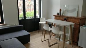 een woonkamer met een tafel en witte stoelen bij Brussels flat in Brussel