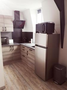 a kitchen with a refrigerator with a microwave on top of it at Appartement moderne avec balnéothérapie in Mers-les-Bains