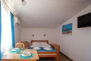 a small bedroom with a bed and a table at Arcobaleno Apartments in Piran