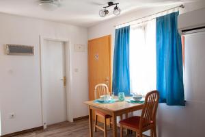 a dining room with a table and chairs and a window at Arcobaleno Apartments in Piran