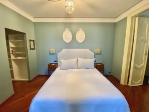 a bedroom with a large white bed with blue walls at Palazzo Mantua Benavides Suites & Apartments in Padova