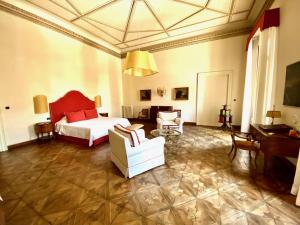 ein Schlafzimmer mit einem Bett, einem Sofa und einem Stuhl in der Unterkunft Palazzo Mantua Benavides Suites & Apartments in Padua